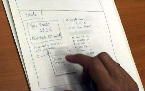 hand pushing button on a paper prototype for Giffgaff